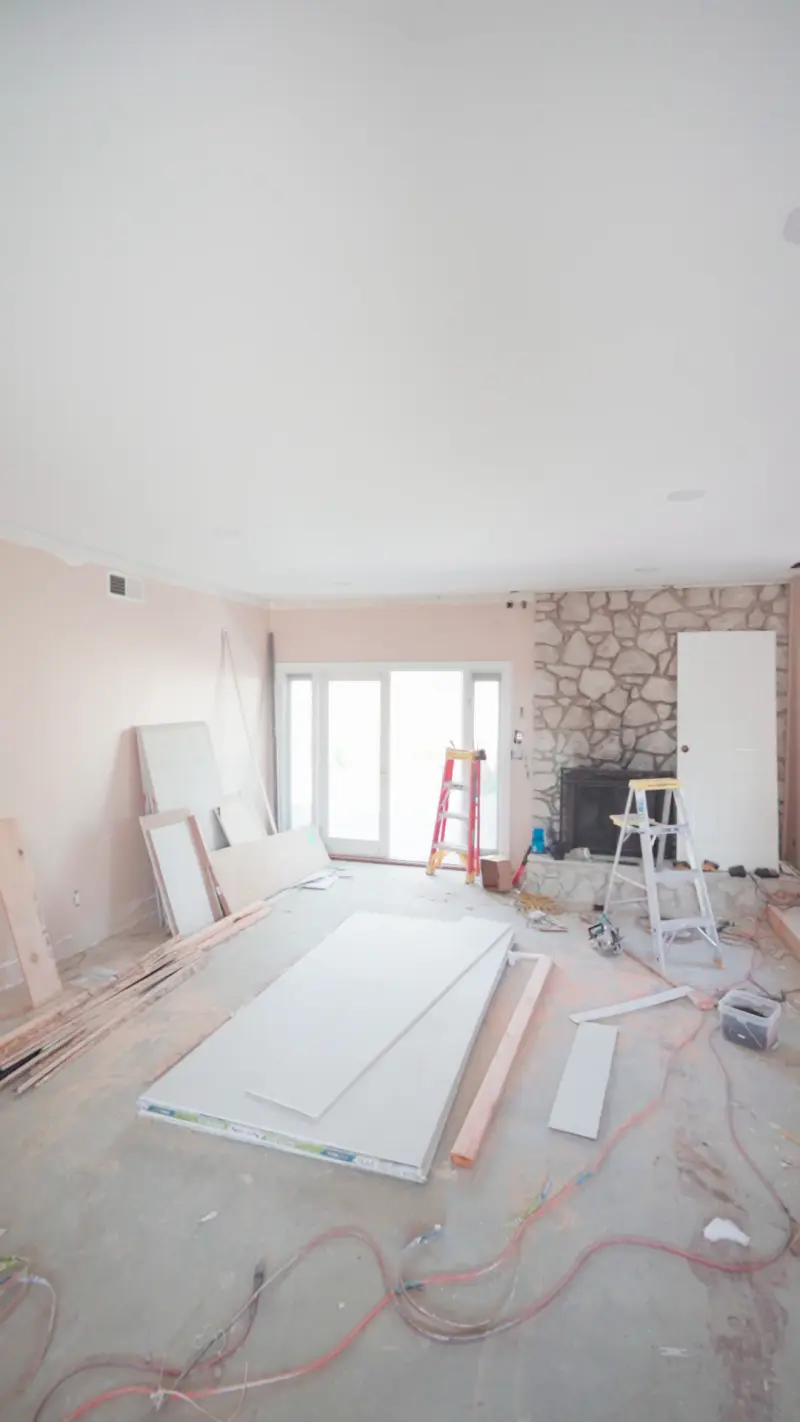 Living room with the stone fireplace and drywall staged